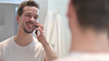 Ayna 'da Akıllı Telefondan Konuşan Genç Adam