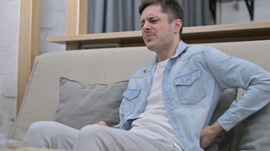 Koltukta otururken sırtı ağrıyan yorgun genç adam