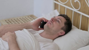 Yatakta Akıllı Telefonla Konuşan Neşeli Genç Adam
