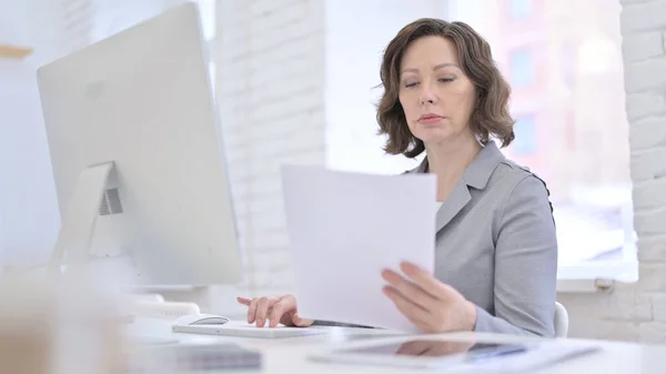 Kreative alte Frau arbeitet an Dokument und Desktop — Stockfoto