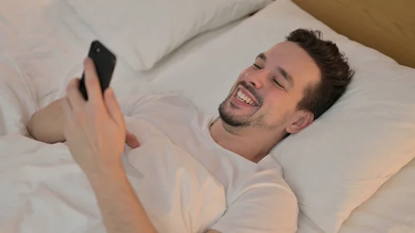 Man doet video Chat op Smartphone in bed — Stockfoto