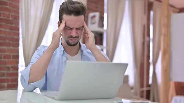 Kopfschmerzen, angespannter junger Mann mit Laptop zu Hause — Stockfoto