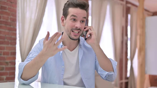 Angry Young Man having Argument on Smartphone