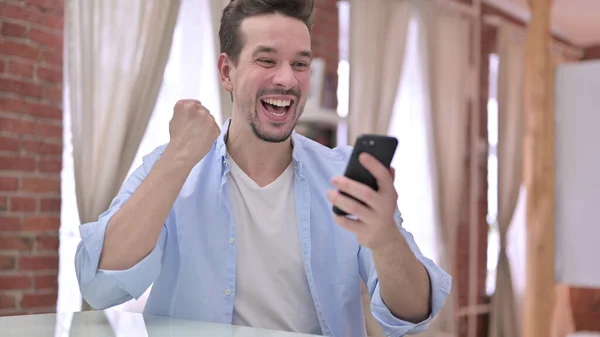 Junger Mann feiert zu Hause mit Smartphone — Stockfoto