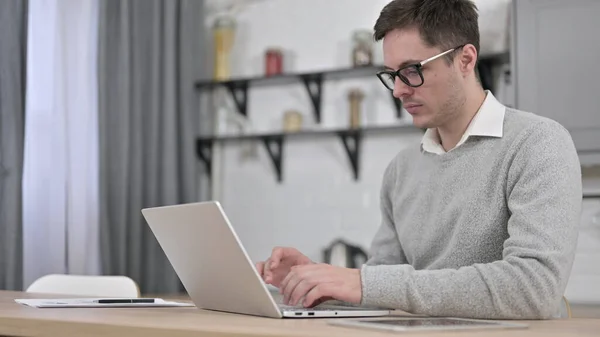 Jongeman die thuis aan laptop werkt — Stockfoto