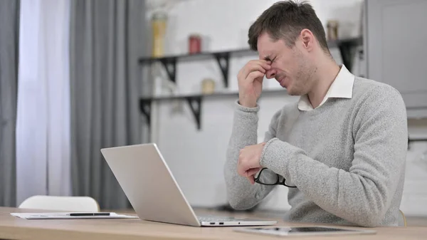 Yorgun Adam dizüstü bilgisayarla uğraşırken baş ağrısı çekiyor — Stok fotoğraf
