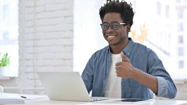 Çalışan ve Başparmaklarını gösteren genç Afrikalı Adam