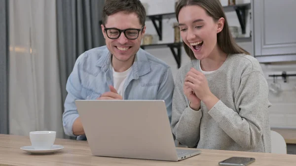 兴奋的年轻夫妇在家中庆祝笔记本电脑的成功 — 图库照片