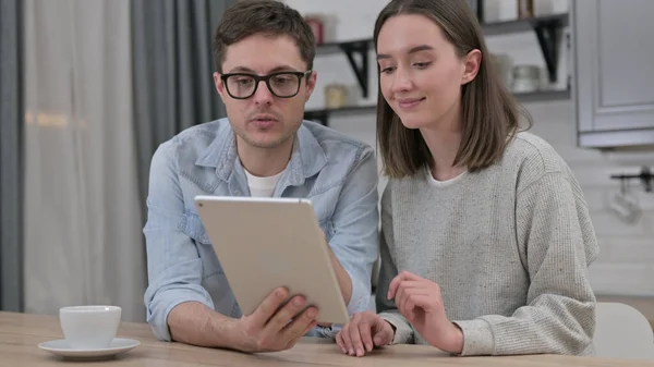 Aantrekkelijk jong paar met behulp van Tablet in de woonkamer — Stockfoto