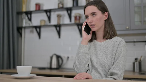 Jovem mulher falando em Smartphone na sala de estar — Fotografia de Stock