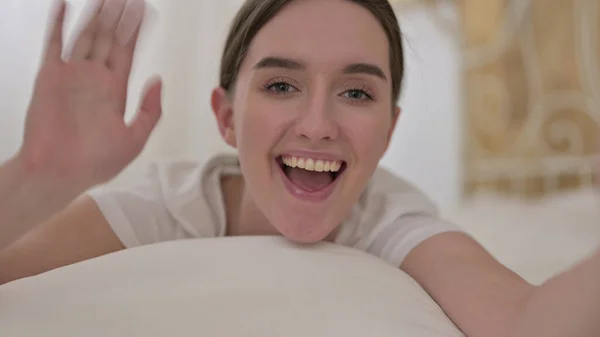 Online video chat v posteli, mluvící mladá žena — Stock fotografie
