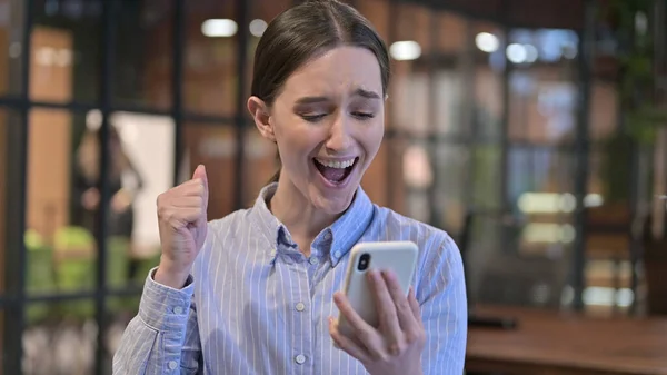 Mujer joven celebrando el éxito en el teléfono inteligente — Foto de Stock
