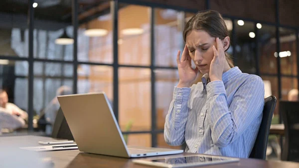 Frau mit Kopfschmerzen arbeitet am Laptop — Stockfoto