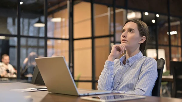 Jeune femme pensant tout en se relaxant au travail — Photo