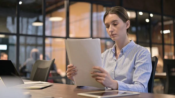 Jeune femme lisant des documents au travail, paperasserie — Photo