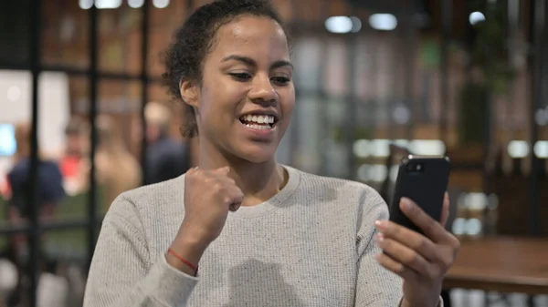 Afrikanerin feiert Erfolg per Smartphone — Stockfoto