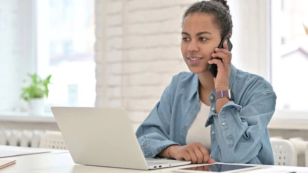 Jovem mulher africana falando em Smartphone no escritório — Fotografia de Stock