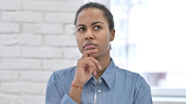 Nachdenkliche junge Afrikanerin denkt über neue Idee nach — Stockfoto