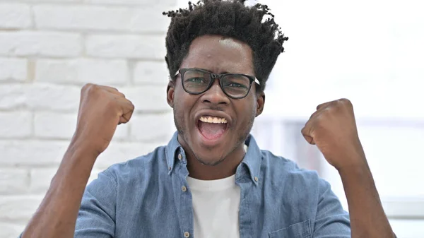 Spännande ung afrikansk man firar framgång — Stockfoto