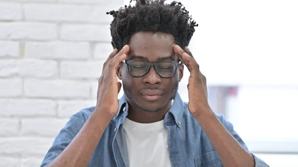 Yorgun ve başı ağrıyan Afrikalı bir genç. — Stok fotoğraf