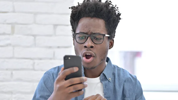 Nadšený mladý Afričan překvapen dobrou zprávou na Smartphone — Stock fotografie