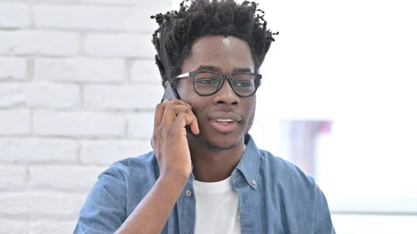 Ung afrikansk man pratar på smartphone — Stockfoto