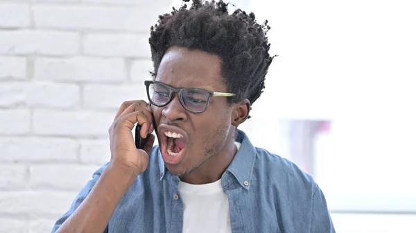 Rozzlobit mladý Afričan rozzlobený na Smartphone — Stock fotografie