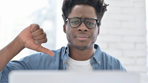 Porträtt av ung afrikansk man visar tummar ner på jobbet — Stockfoto