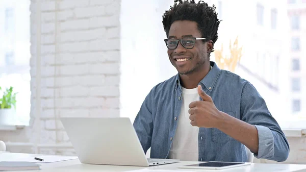 Ung afrikansk man Arbetar och visar tummen upp — Stockfoto