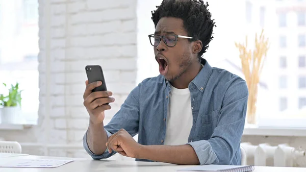 Jovem homem africano obter surpresa no smartphone — Fotografia de Stock