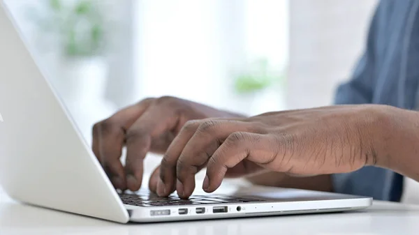 Nahaufnahme eines jungen Afrikaners beim Tippen auf der Tastatur — Stockfoto