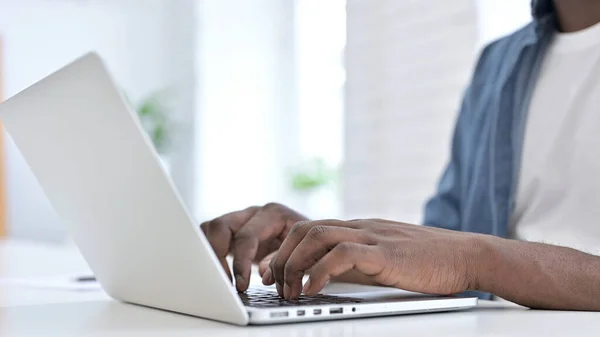 Nahaufnahme junger afrikanischer Mann bei der Arbeit am Laptop — Stockfoto