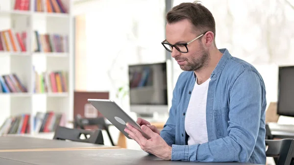 Jovem de óculos usando tablet no trabalho — Fotografia de Stock