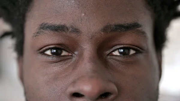 Gros plan sur les yeux clignotants de l'homme africain — Photo