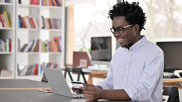 Sukces płatności online na laptopie przez African Man — Zdjęcie stockowe