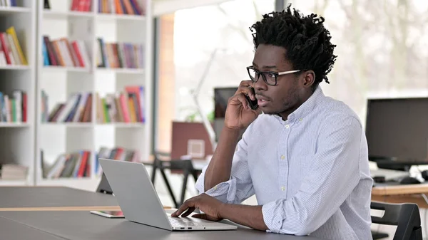 African Man Mówienie na smartfonie w pracy — Zdjęcie stockowe