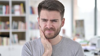 Diş ağrısı ve diş enfeksiyonu olan genç bir adamın portresi.