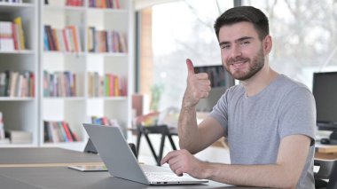 Ofisinde dizüstü bilgisayarı olan Genç Adam Başparmağını kaldırdı