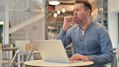 Cafe 'de dizüstü bilgisayar öksürüğü kullanan hasta sıradan bir adam.