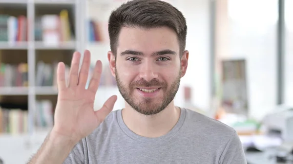 Portret van een opgewonden jonge man zwaaiend naar de camera, — Stockfoto