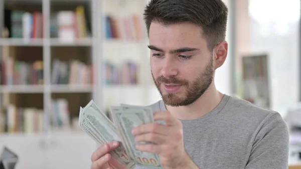 Porträt eines jungen Mannes, der Dollar zählt — Stockfoto