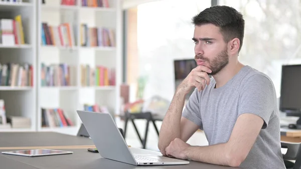 Pensive Young Man Thinking New Plan in Office