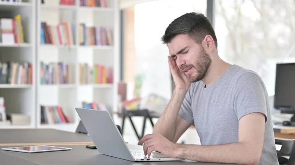 Jonge man met hoofdpijn met behulp van Laptop in Office — Stockfoto