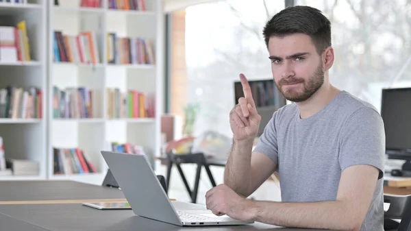 Nessun segno del dito del giovane con il computer portatile in ufficio — Foto Stock