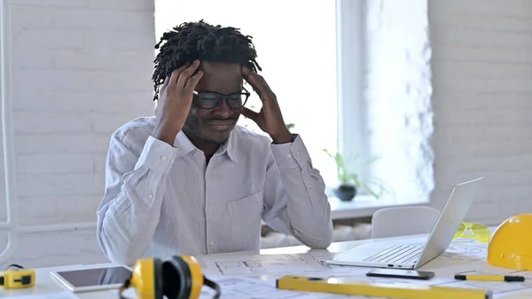 Frustrated African Architecture Engineer with Headache in Office