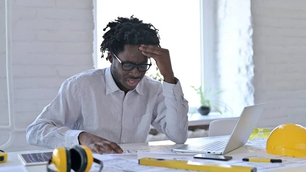 Stressed African Architect doing Paperwork in Office