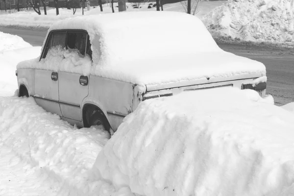 Old car in winter in snow on road, black and white photo — Stock Photo, Image