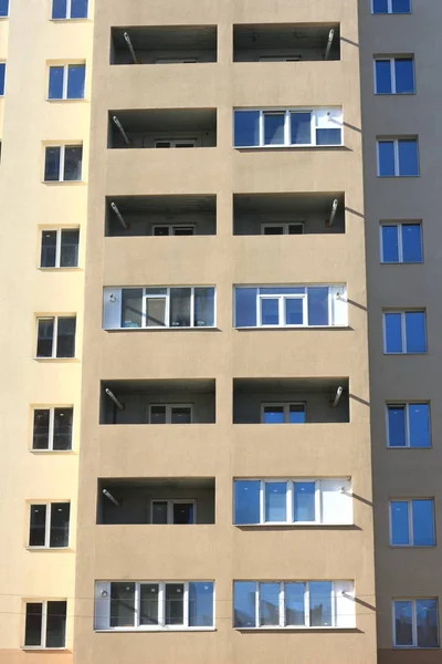 Gevel van een mooie meerdere verdiepingen modern gebouw met ramen en balkons close-up — Stockfoto