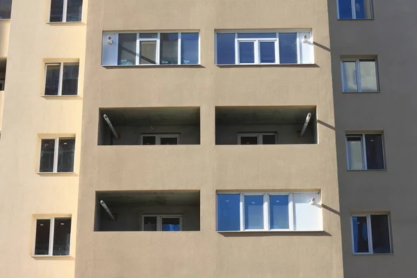 Gevel van een mooie meerdere verdiepingen modern gebouw met ramen en balkons close-up — Stockfoto