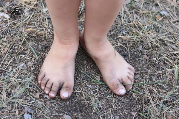 Las piernas del niño en verano en el suelo sin zapatos primer plano —  Fotos de Stock